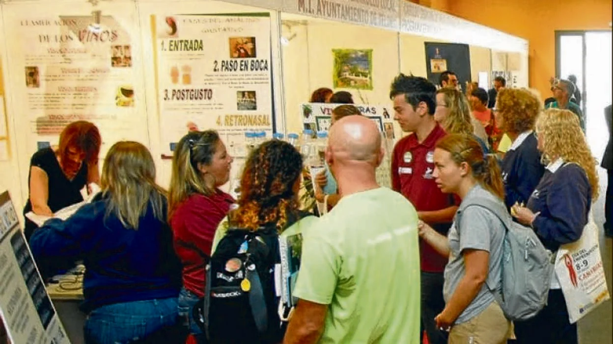 Personas visitando una feria informativa en Canarias. Noticia de Canarias7 sobre el liderazgo regional en emprendeduría (2008).